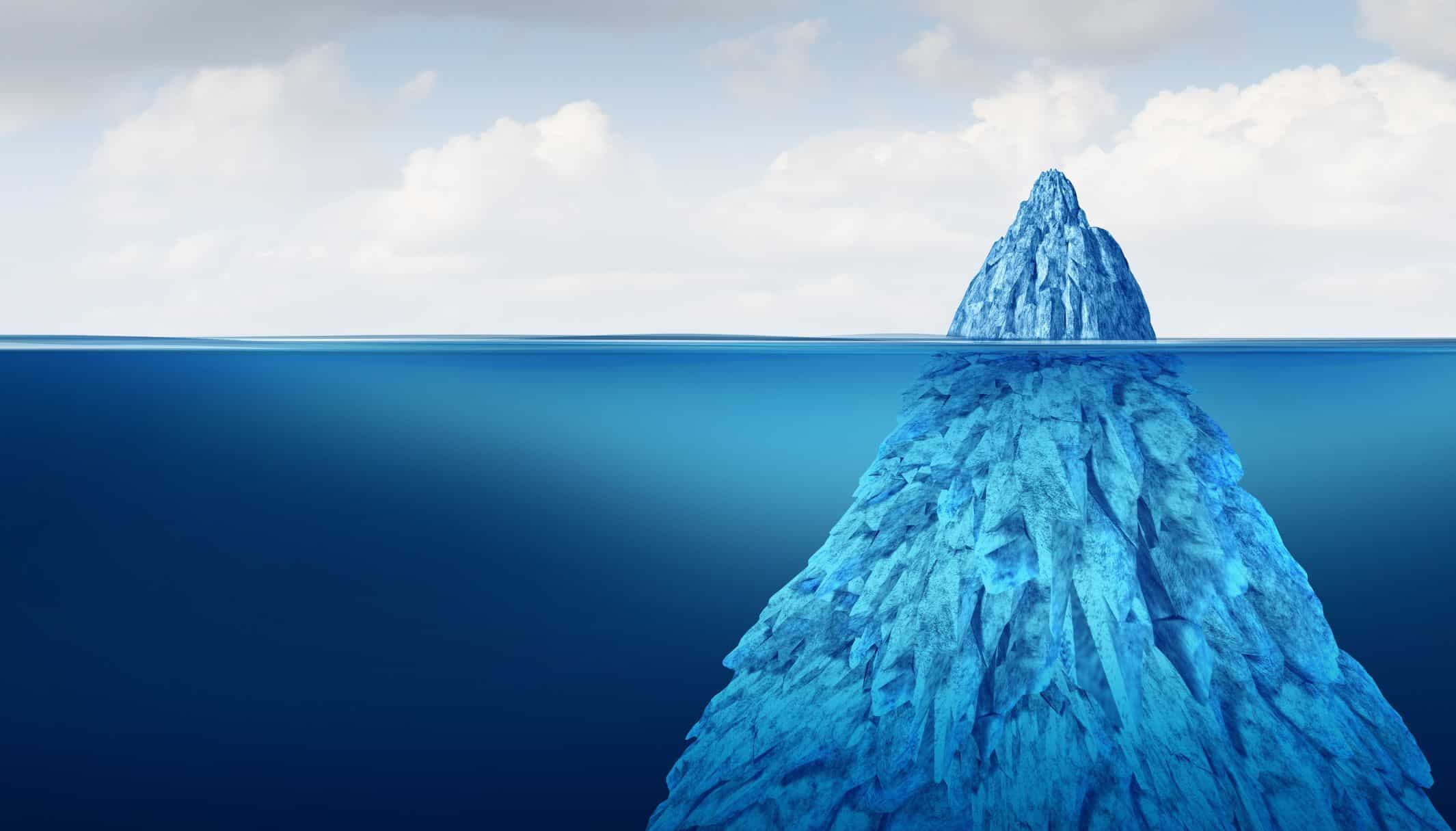 An iceberg with a small peak above the waterline and a far larger mass below it.