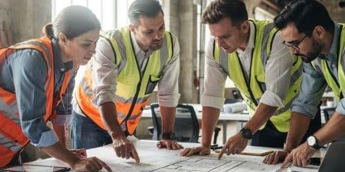 Group around architecture drawing on table